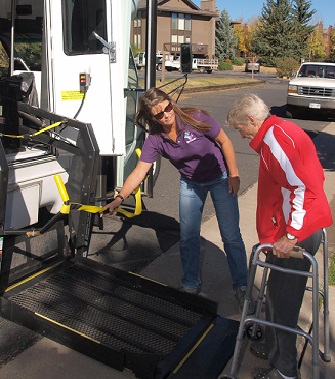 Driver assists elderly passenger onto shuttle