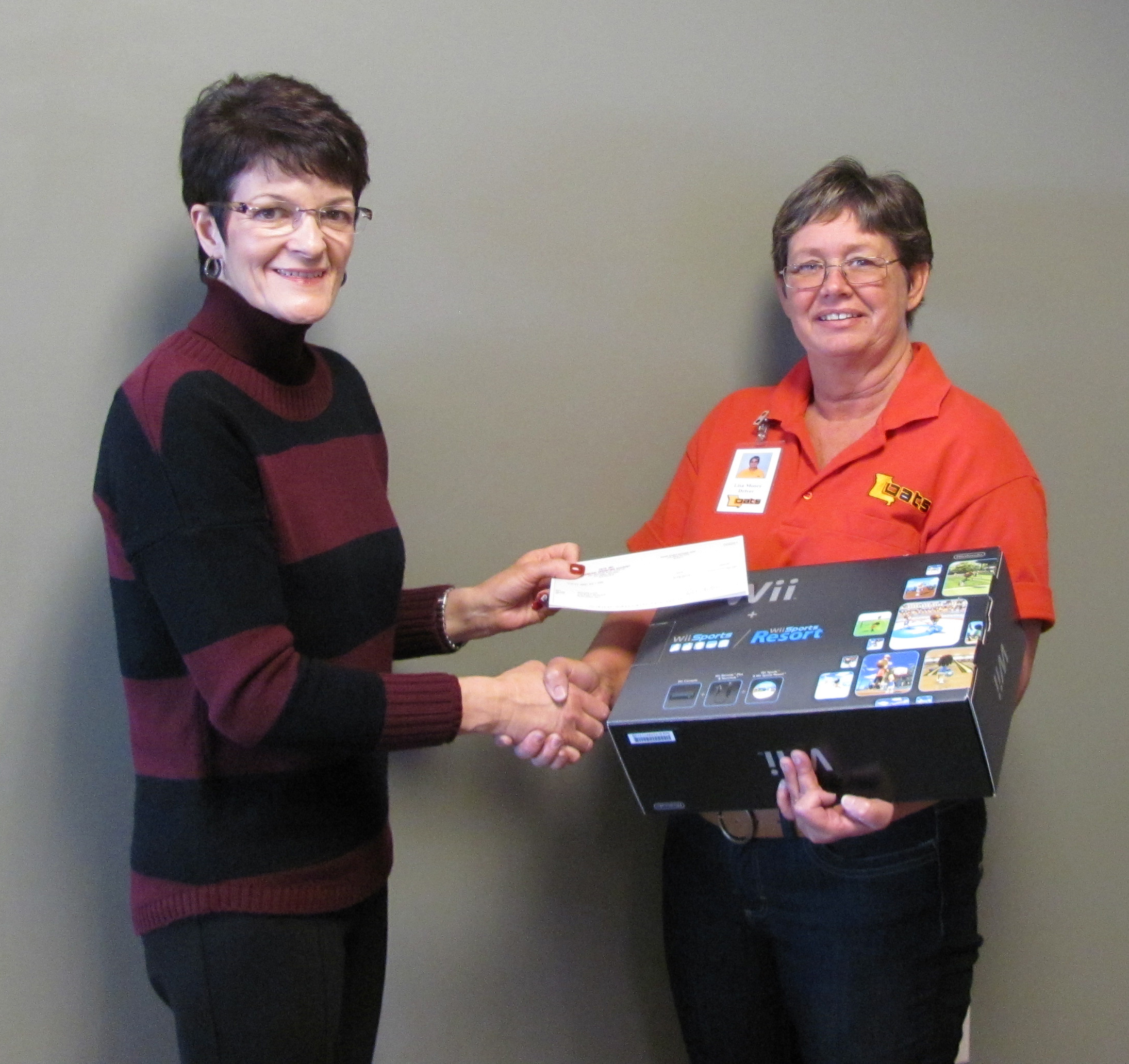 Sheree Webb presents driver Lisa Moore with a prize for winning a wellness challenge