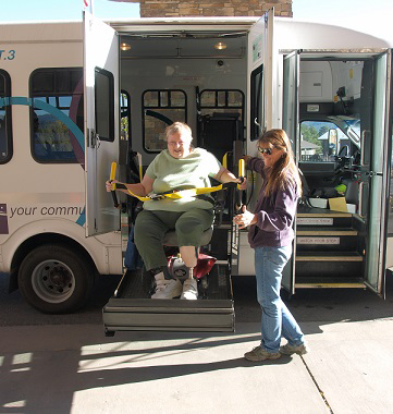 Driver assists handicapped passenger on lift